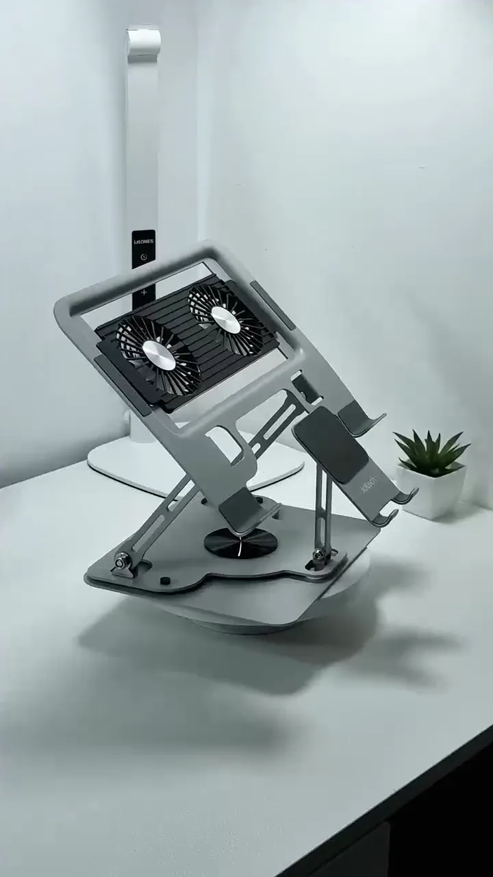 A laptop on an adjustable cooling stand with a phone holder