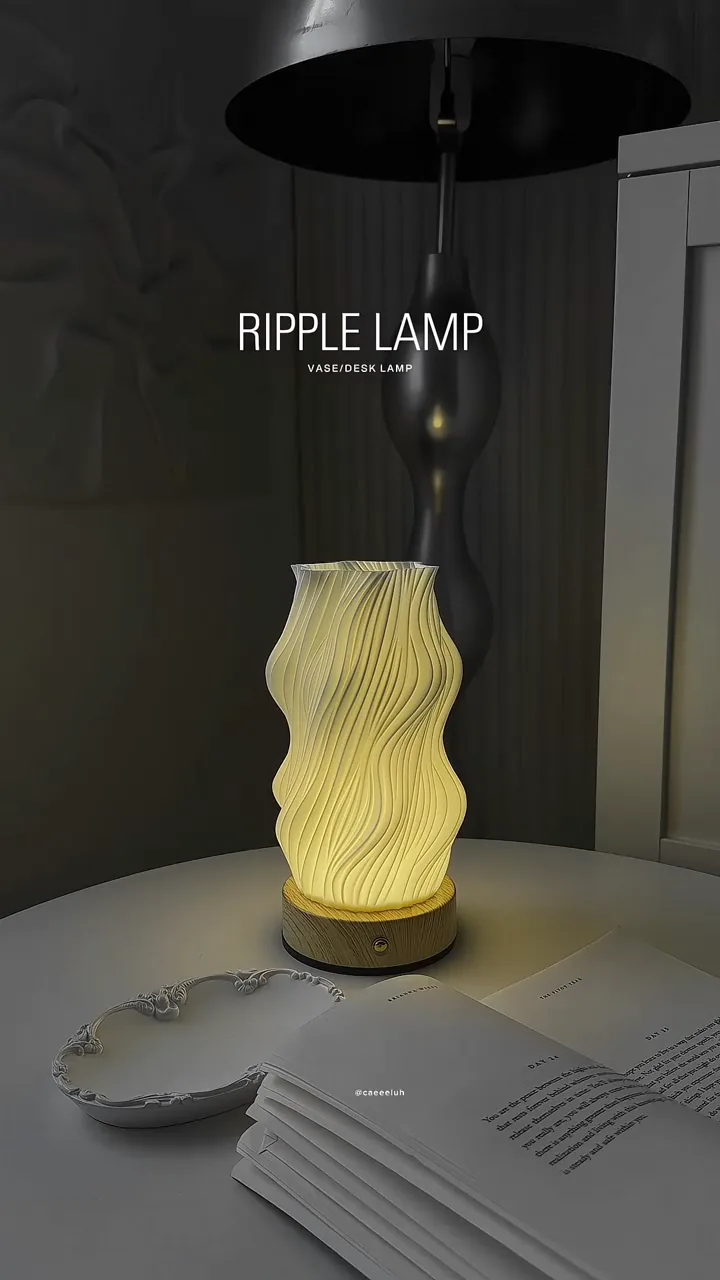 A warm illuminated table lamp with a rippled shade beside an open book
