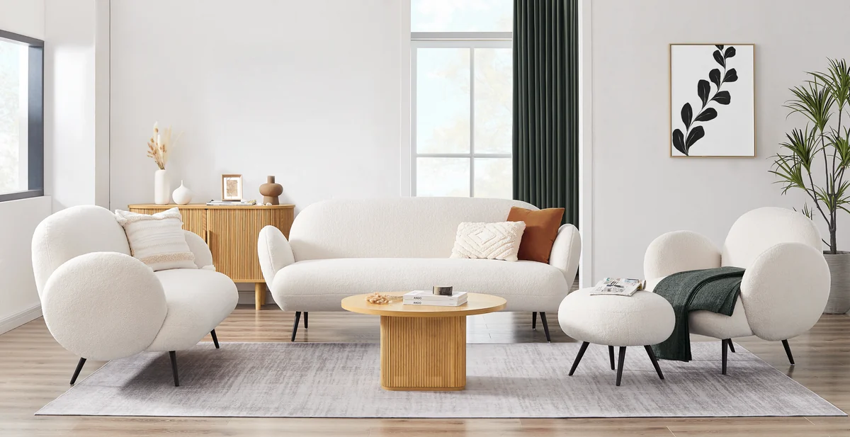 Cream sofa, chairs, and wooden tables in a bright living-room setting